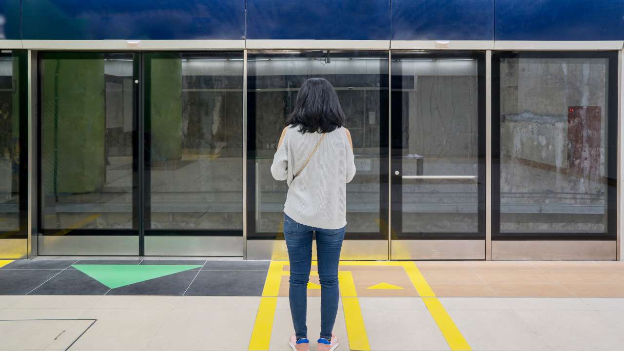 a girl standing in front of the mrt gates